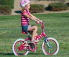 Девочка на велосипеде в парке весной